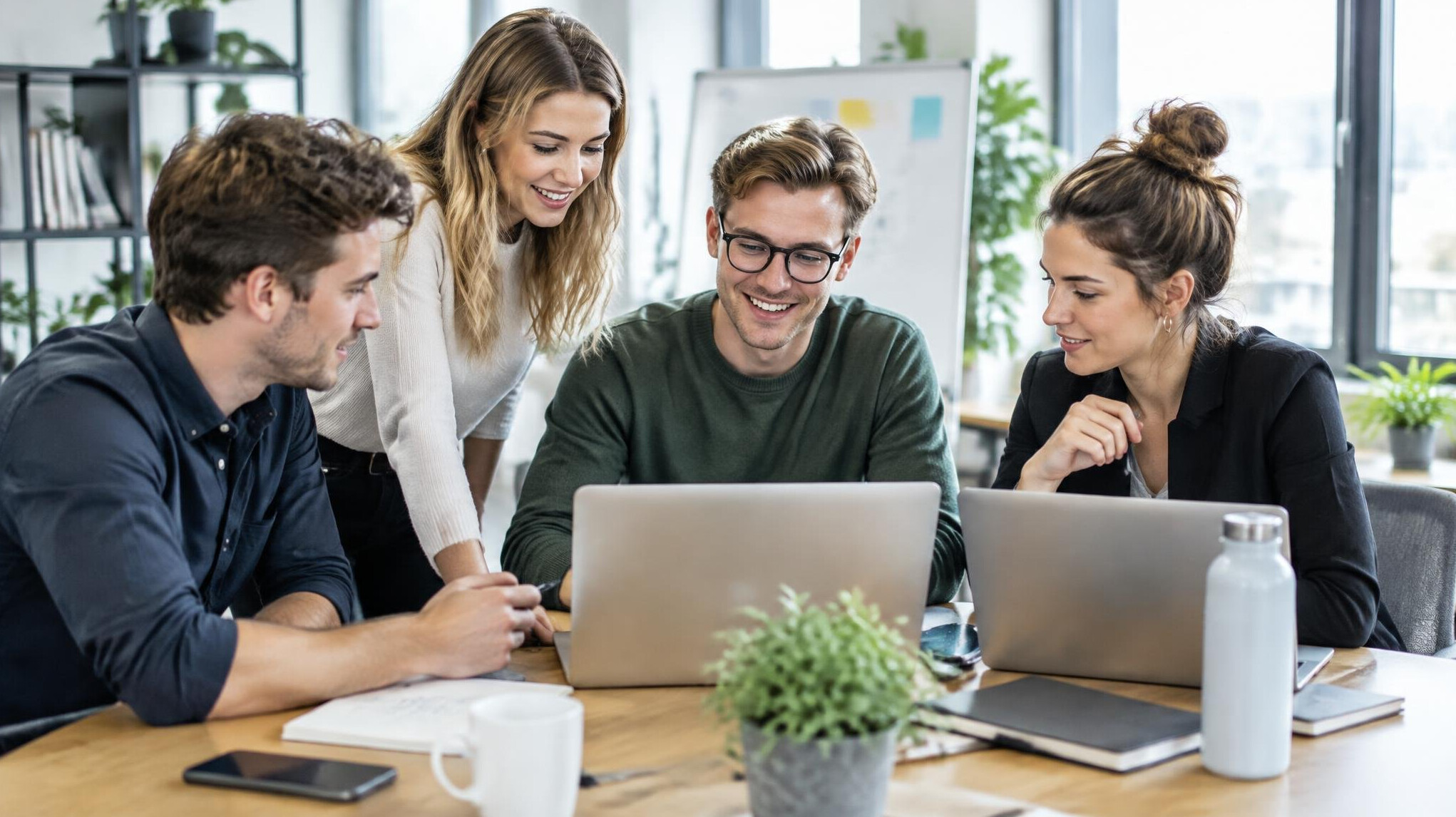 Team collaborating with laptops in an office